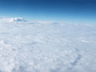 Airplane view of clouds, Gina Conroy, author and teacher shows you how to do remote work from anywhere.